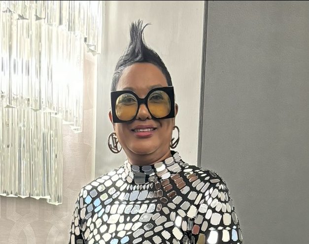 A Woman In A Silver And Black Dress Wearing Black And Yellow Sunglasses